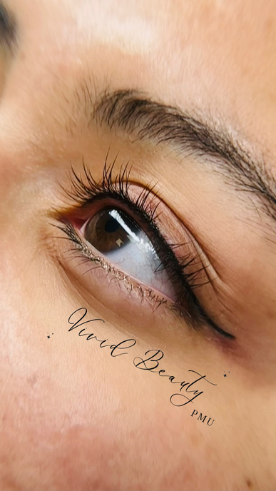 a close up of an eye with eyelash lift and recent eyeliner permanent tattoo